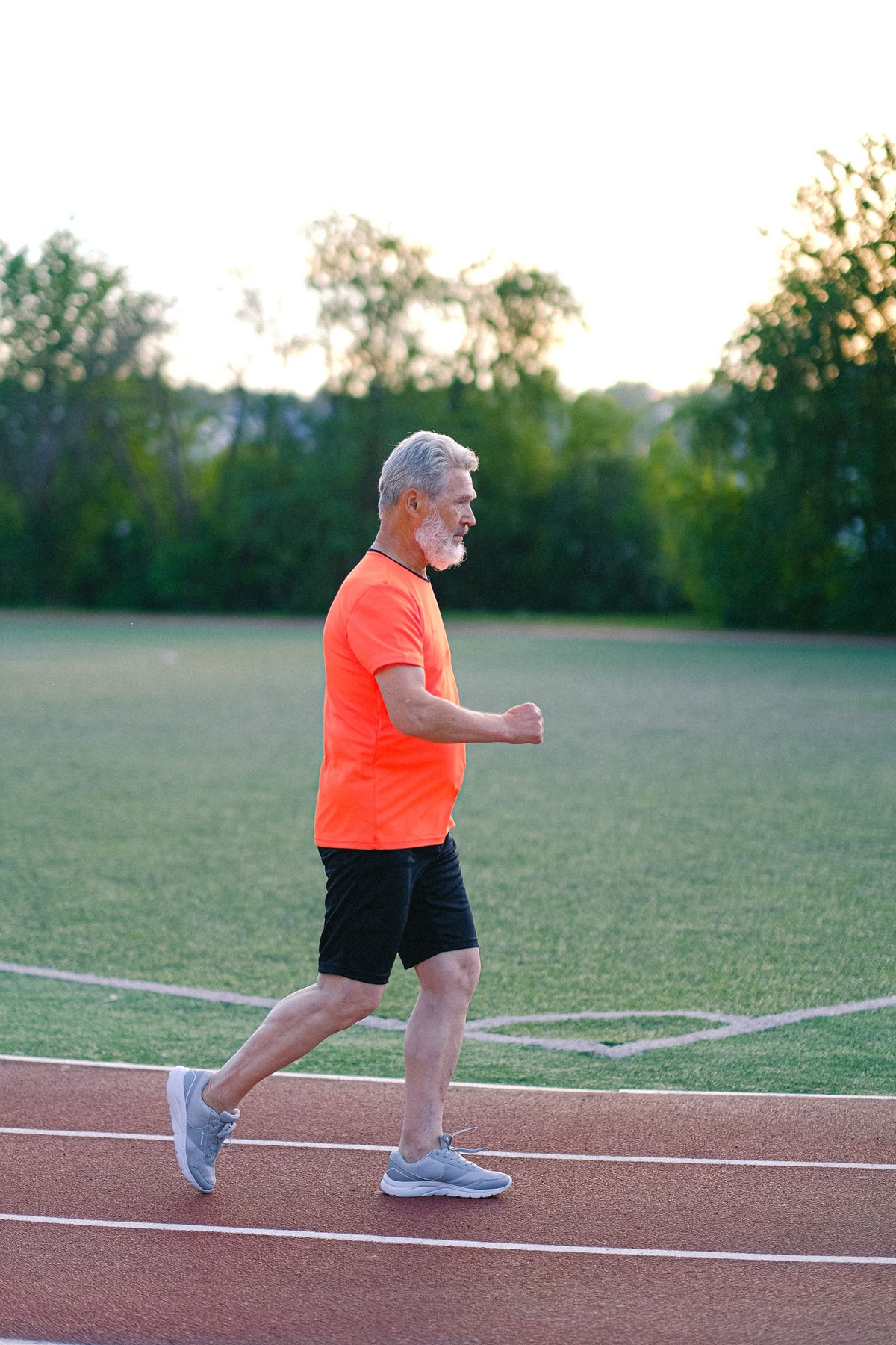 Gray-haired man running on a track